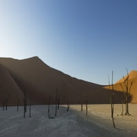 Sunrise počinje osvijetliti pješčane dine koje okružuju mrtvo, dio pustinje Namib u Sossusvleiju; Namibia